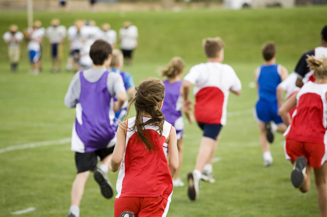 Bambini su un campo di calcio che corrono